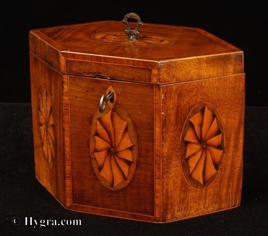 Enlarge Picture: Hexagonal single compartment tea caddy veneered with satinwood and inlaid with marquetry ovals depicting paterae. The top and front have a framing of cross banded kingwood. The caddy retains some of its original leading. 1790       